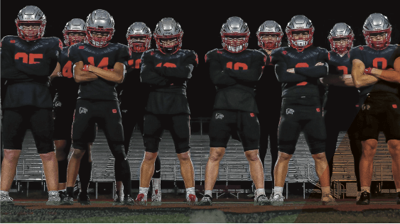 Group of youth Football players in uniform standing with arms crossed and serious expressions